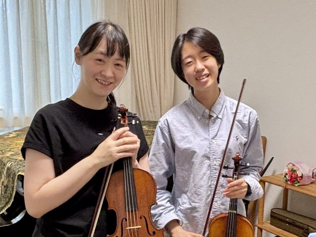 バイオリンを持って笑顔で並ぶ講師と中学3年生の生徒